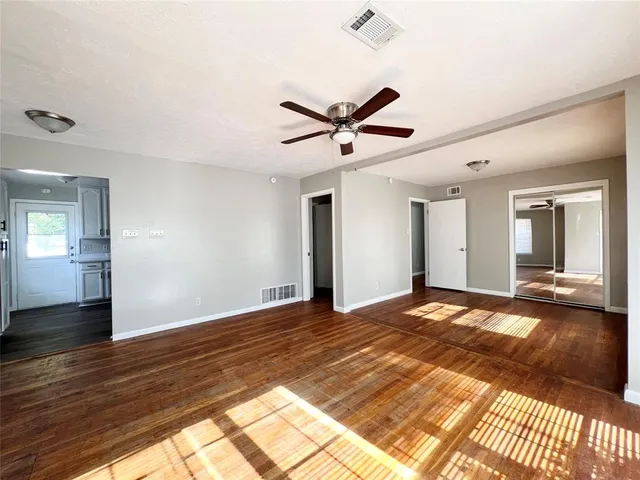 a view of a room with wooden floor and ceiling fan