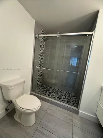 a bathroom with a shower a toilet and sink