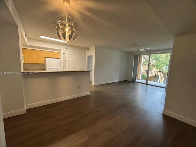 a view of a room with wooden floors and chandelier