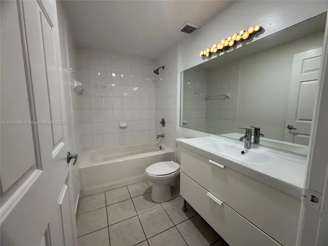 a bathroom with a sink a toilet a mirror and shower