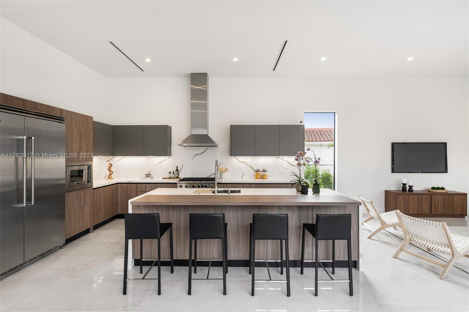 491 Ranch Road Weston, FL 33326 - Photo 16 of 46 a kitchen with stainless steel appliances kitchen island granite countertop a table chairs stove and refrigerator
