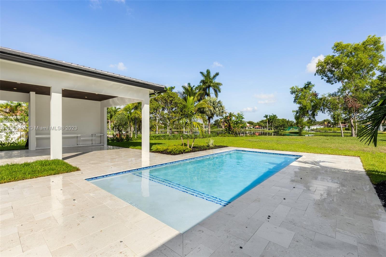 491 Ranch Road Weston, FL 33326 - Photo 38 of 46 a view of swimming pool with seating space and trees in the background