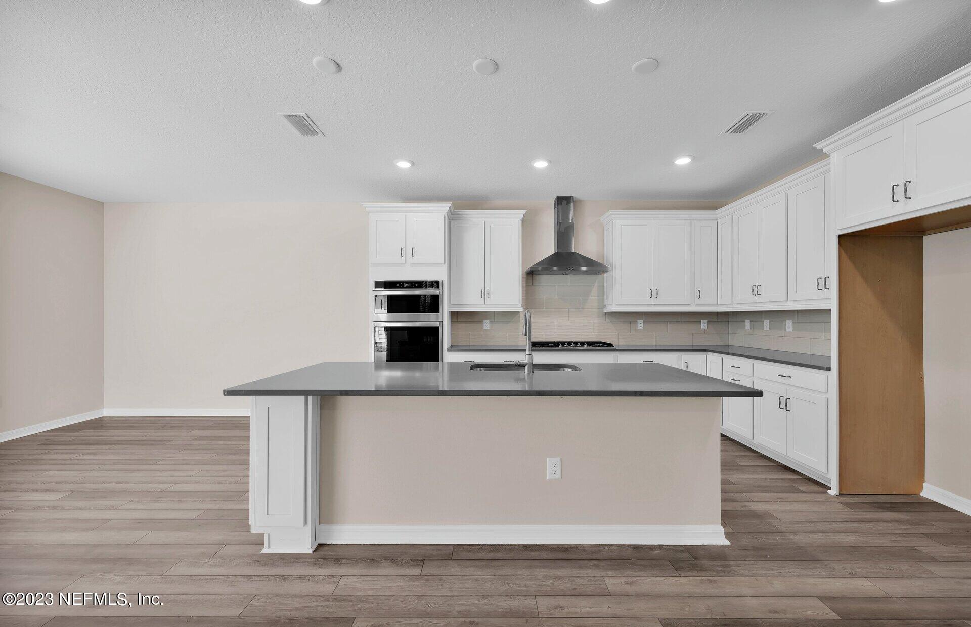338 Red Barn Road St. Augustine, FL 32092 - Photo 11 of 34 a kitchen with stainless steel appliances granite countertop a sink a stove a refrigerator and white cabinets