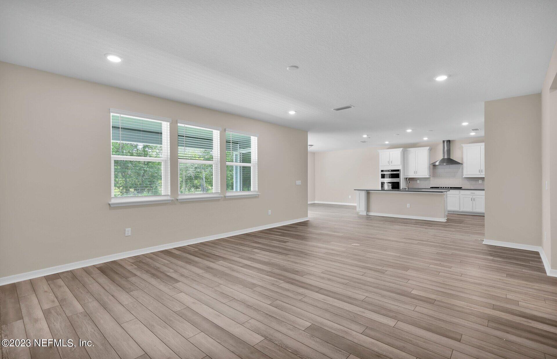 338 Red Barn Road St. Augustine, FL 32092 - Photo 12 of 34 a view of kitchen with kitchen island white cabinets and wooden floor
