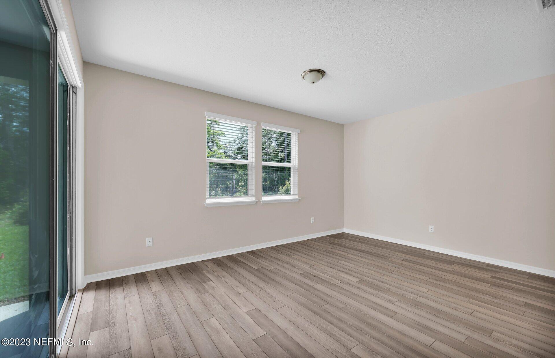 338 Red Barn Road St. Augustine, FL 32092 - Photo 17 of 34 an empty room with wooden floor and windows