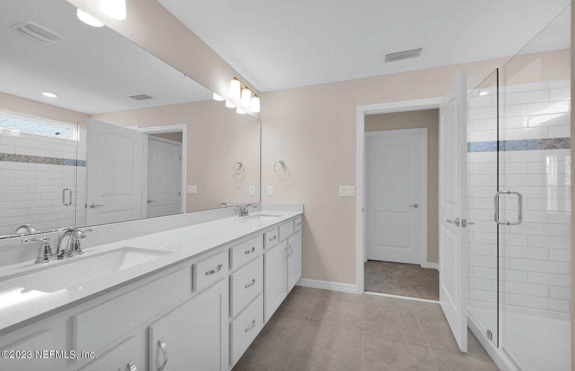 338 Red Barn Road St. Augustine, FL 32092 - Photo 22 of 34 a spacious bathroom with a double vanity sink mirror and shower