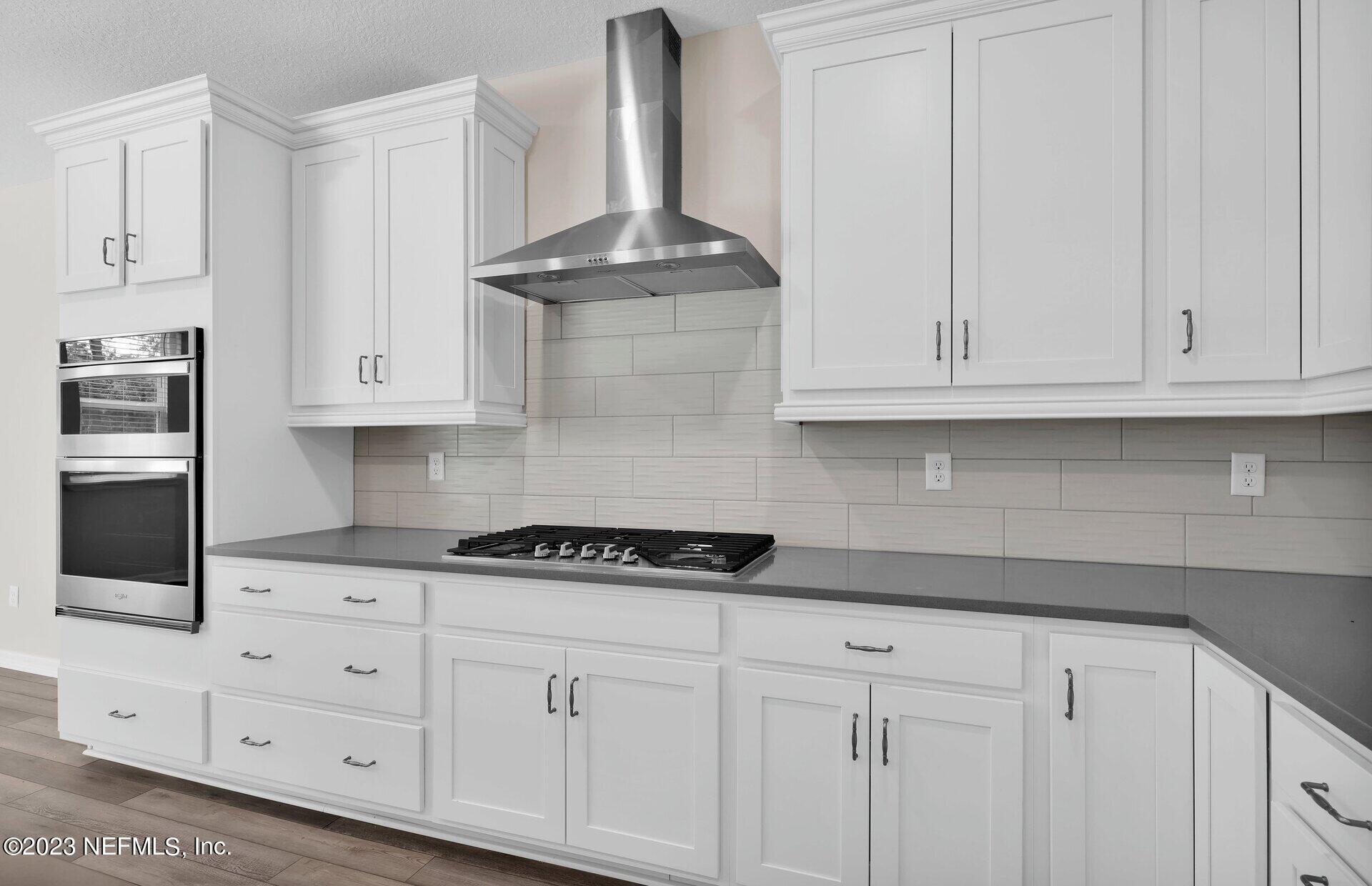 338 Red Barn Road St. Augustine, FL 32092 - Photo 3 of 34 a kitchen with white cabinets and a stove