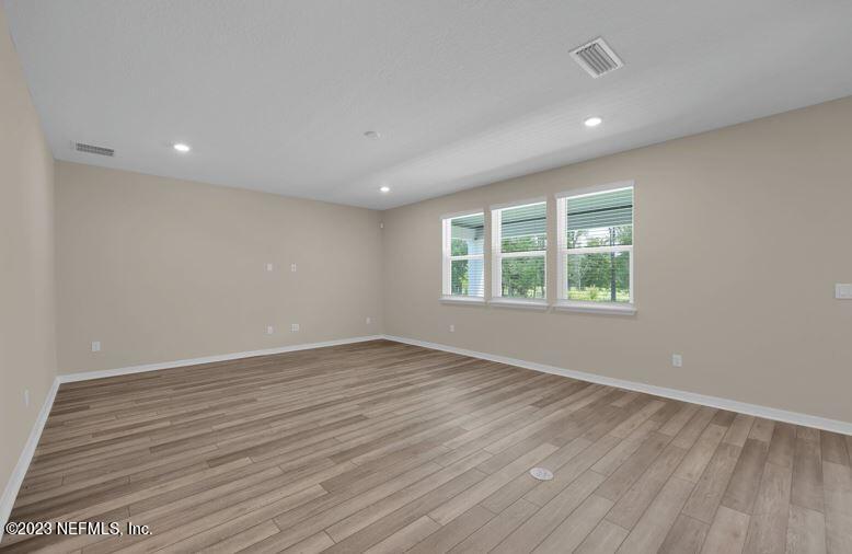 338 Red Barn Road St. Augustine, FL 32092 - Photo 10 of 34 an empty room with wooden floor and windows