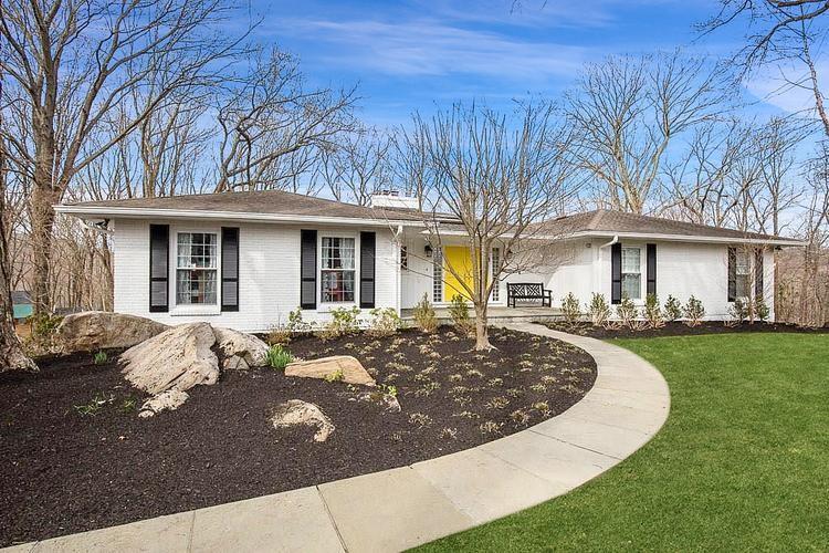a front view of a house with yard porch and outdoor seating