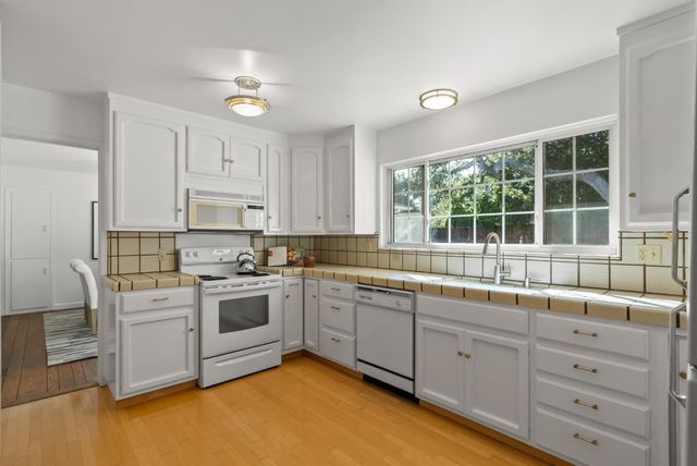 a kitchen with granite countertop white cabinets and sink