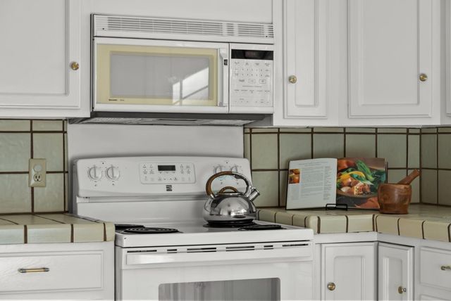a kitchen with white cabinets and white appliances