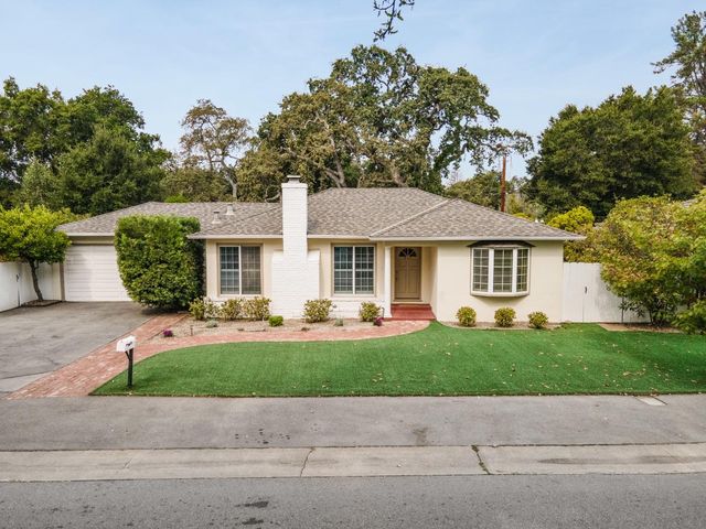 a front view of a house with a yard and potted plants