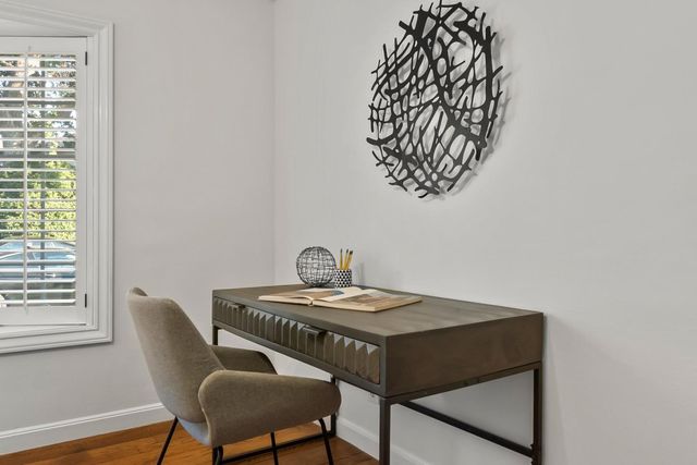 a bedroom with a bed lamp and potted plant