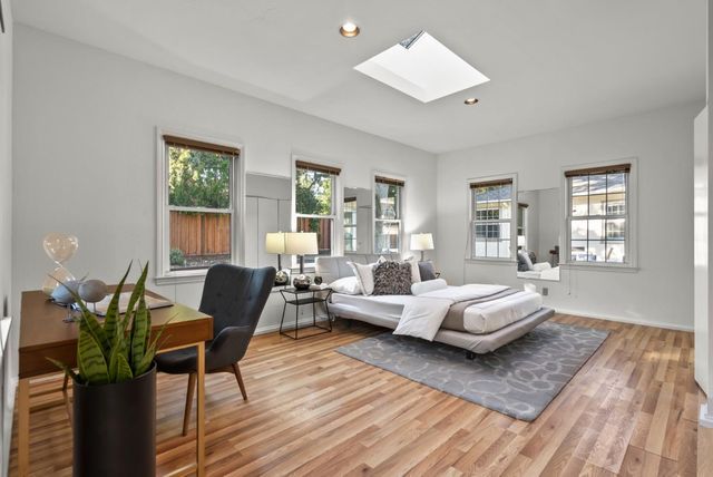 a bedroom with a bed a lamp and large window