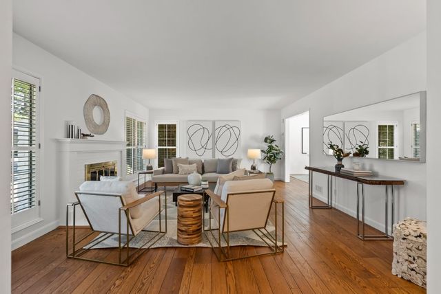a living room with fireplace furniture and a wooden floor