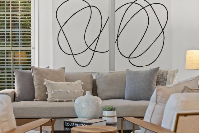 a living room with furniture a white walls and a lamp