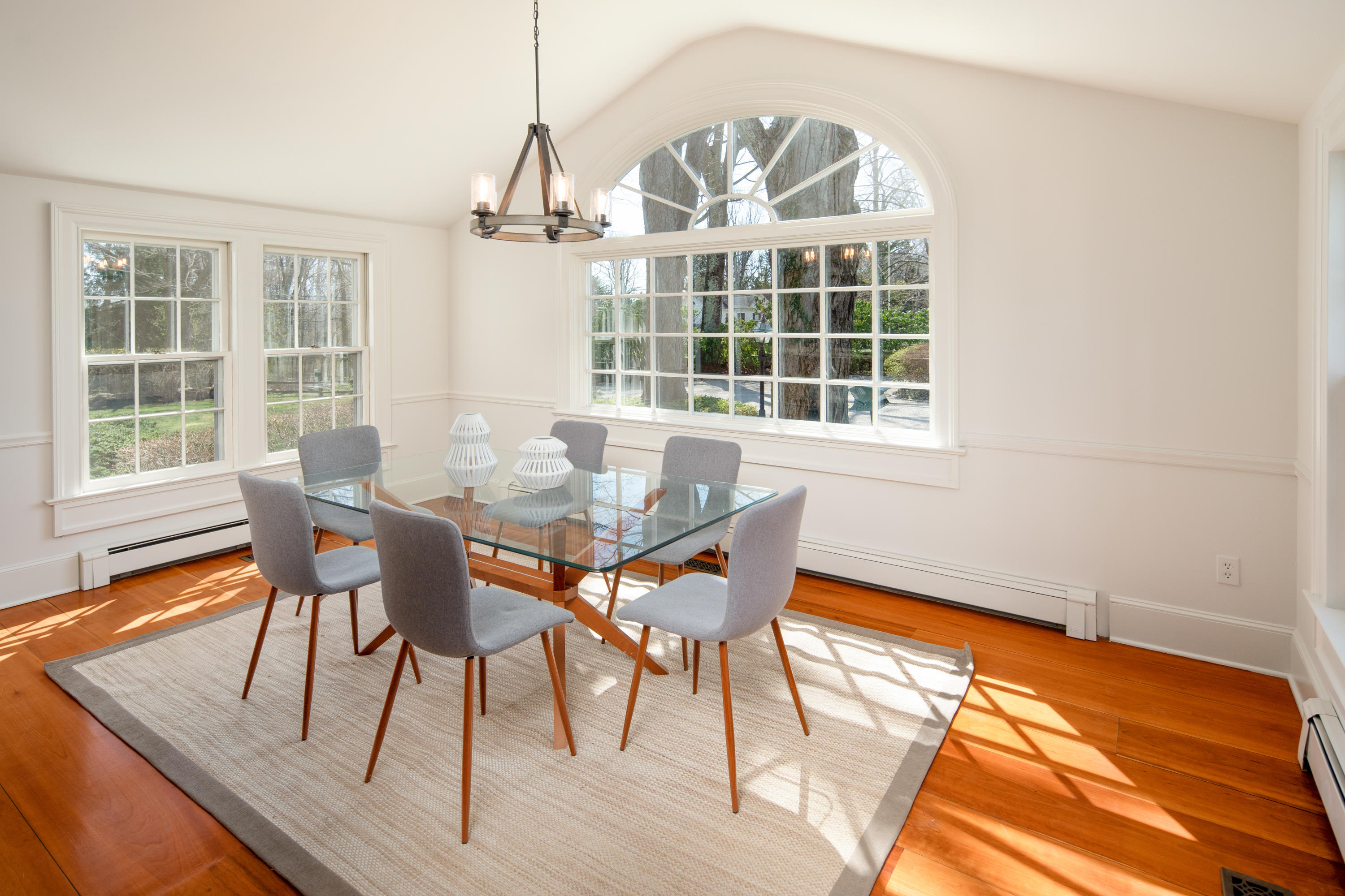 469 Brookside Road New Canaan, CT 06840 - Photo 10 of 39 a dining room with wooden floor a chandelier a wooden table and chairs