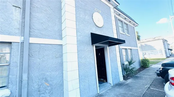 a view of a house with a potted plants and wooden fence