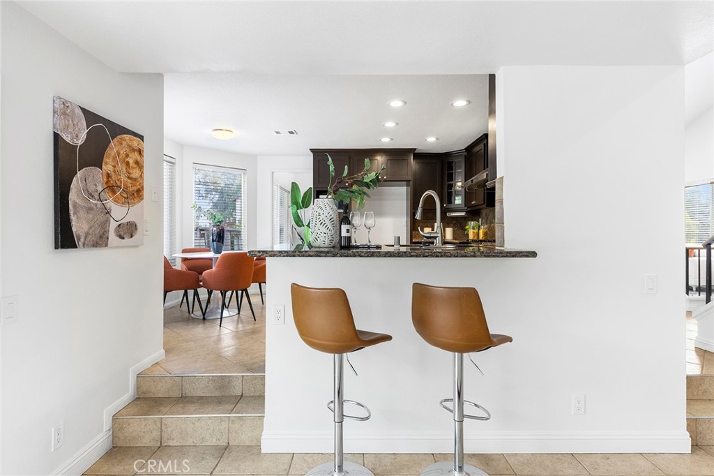 39 Viewpoint Circle Pomona, CA 91766 - Photo 19 of 49 a kitchen with a dining table chairs and a painting on the wall