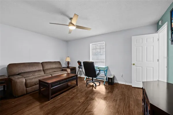 a living room with furniture and a wooden floor