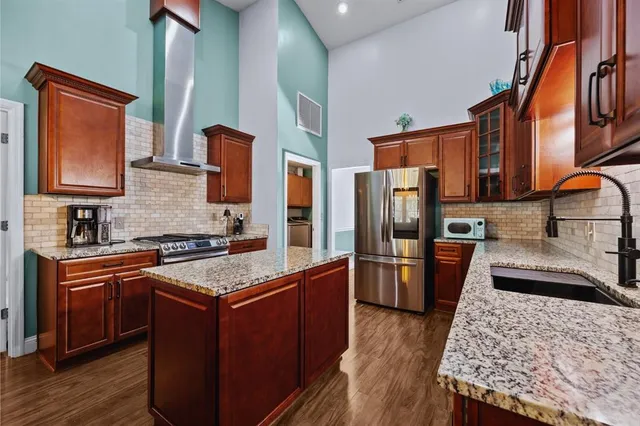 a kitchen with stainless steel appliances granite countertop wooden cabinets a stove top oven a sink and dishwasher