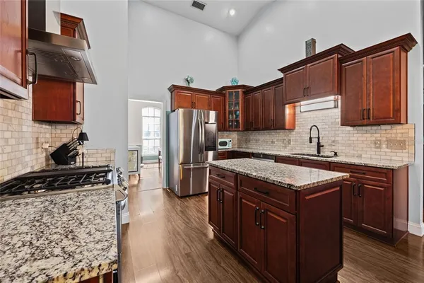 a kitchen with stainless steel appliances granite countertop a stove a sink dishwasher and a refrigerator
