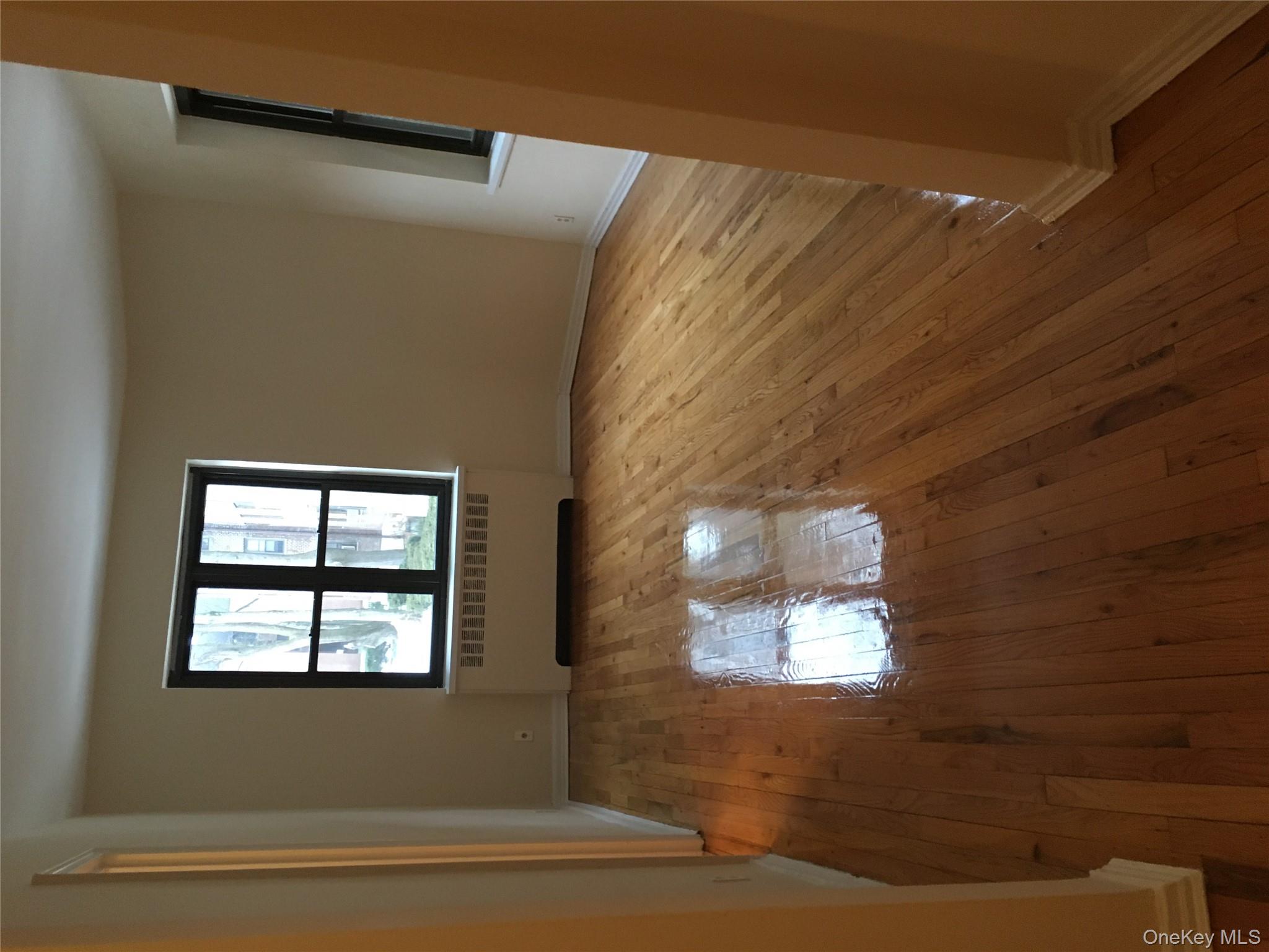 23 Schenck Avenue, Unit 1BD Great Neck, NY 11021 - Photo 11 of 14 an empty room with wooden floor and windows