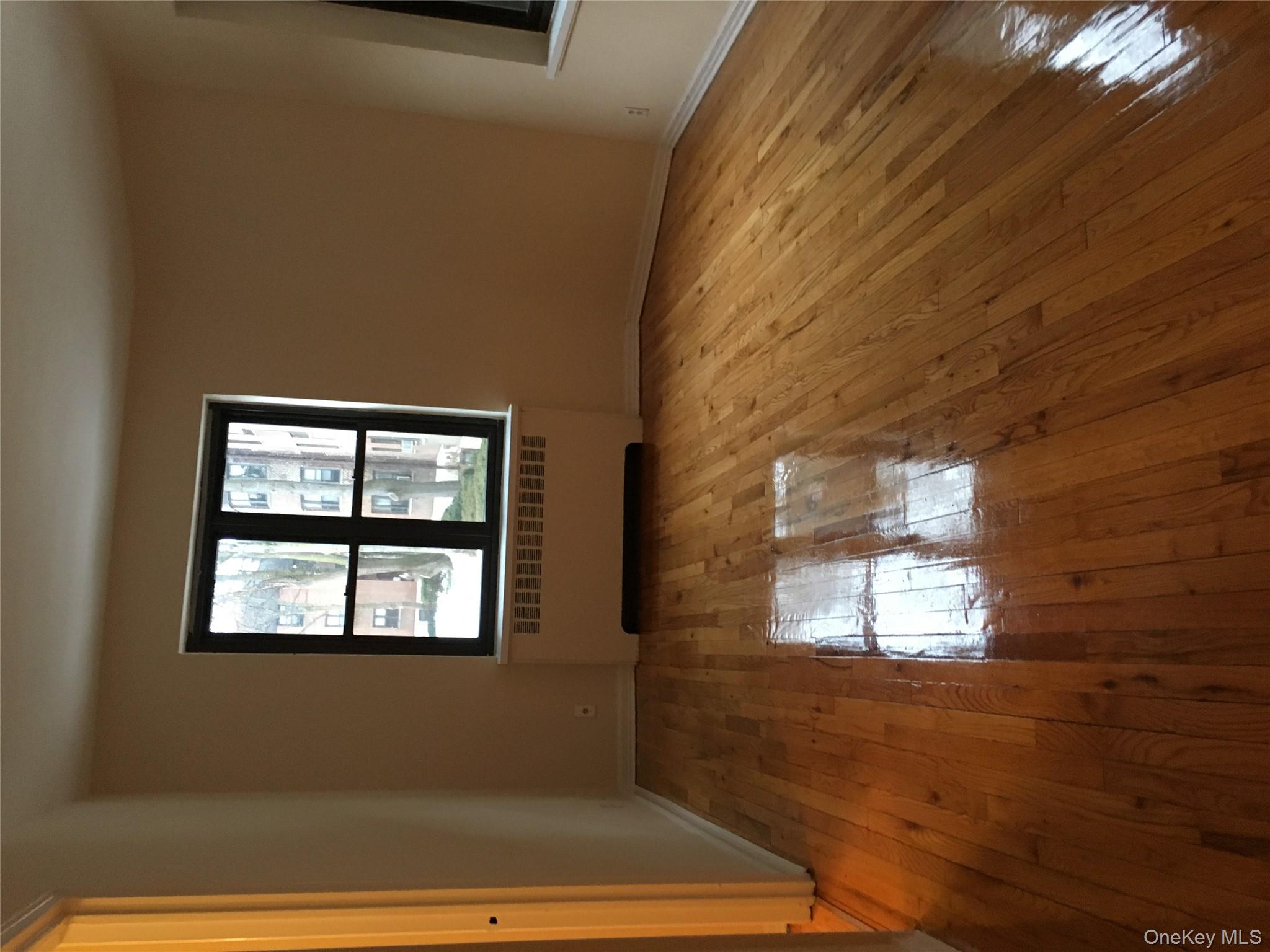 23 Schenck Avenue, Unit 1BD Great Neck, NY 11021 - Photo 12 of 14 an empty room with wooden floor and windows