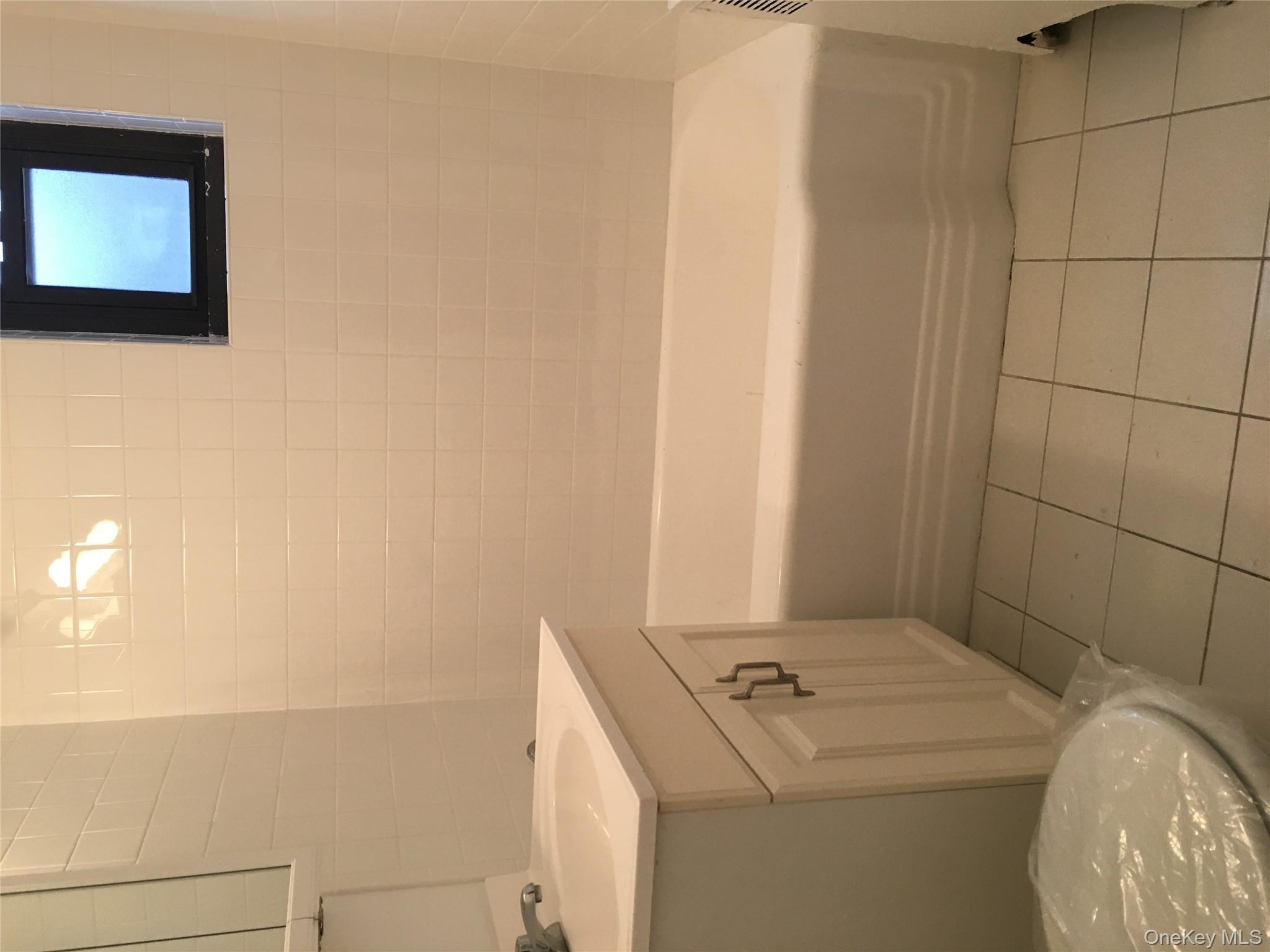 23 Schenck Avenue, Unit 1BD Great Neck, NY 11021 - Photo 14 of 14 a bathroom with a sink a toilet and shower
