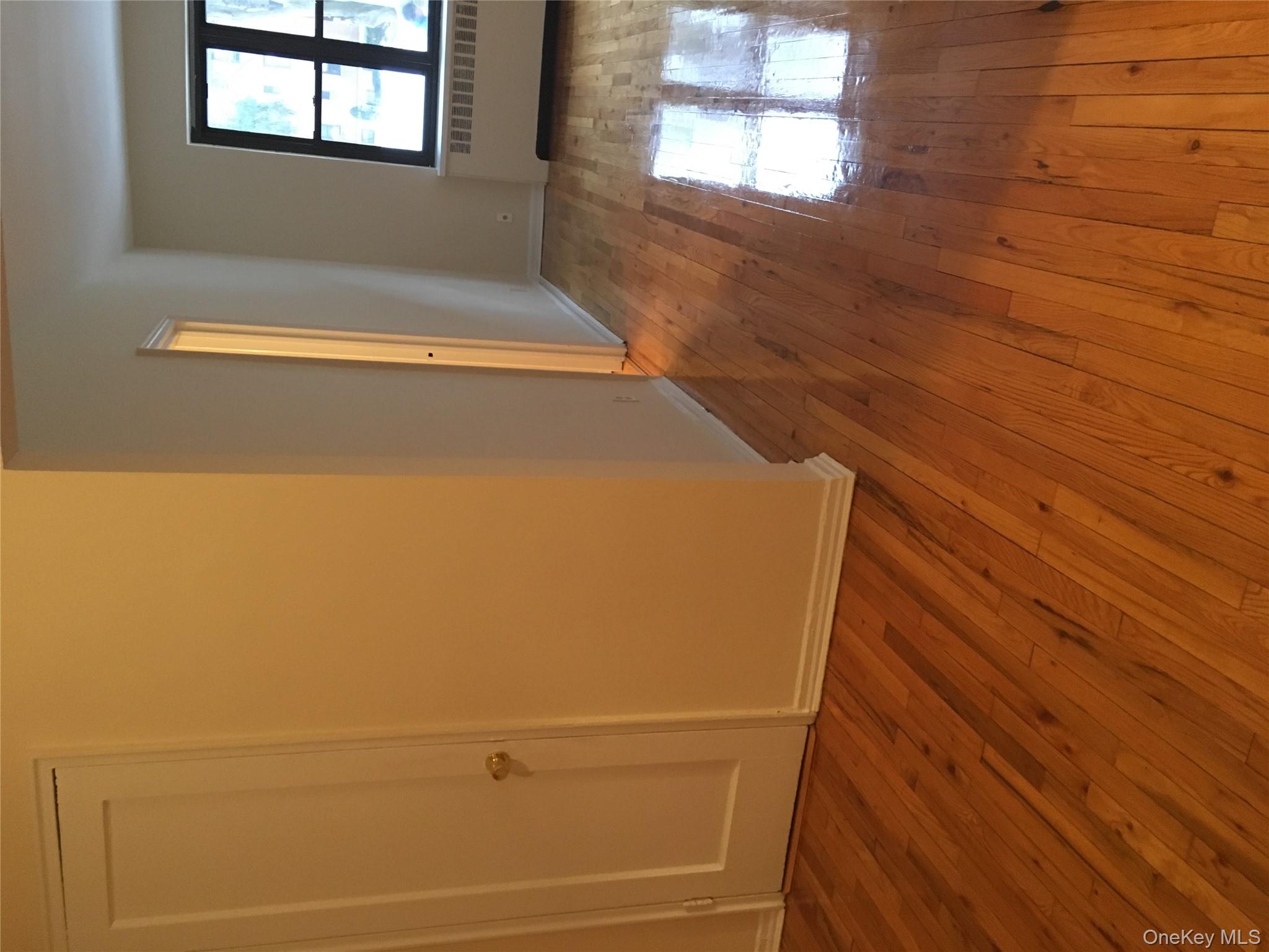 23 Schenck Avenue, Unit 1BD Great Neck, NY 11021 - Photo 2 of 14 an empty room with wooden floor and windows