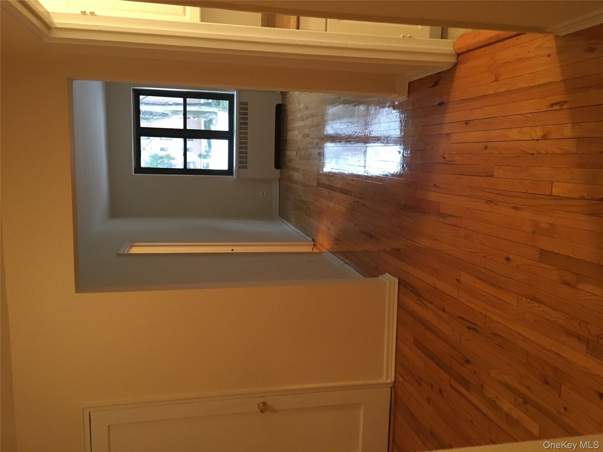 23 Schenck Avenue, Unit 1BD Great Neck, NY 11021 - Photo 3 of 14 an empty room with wooden floor and windows