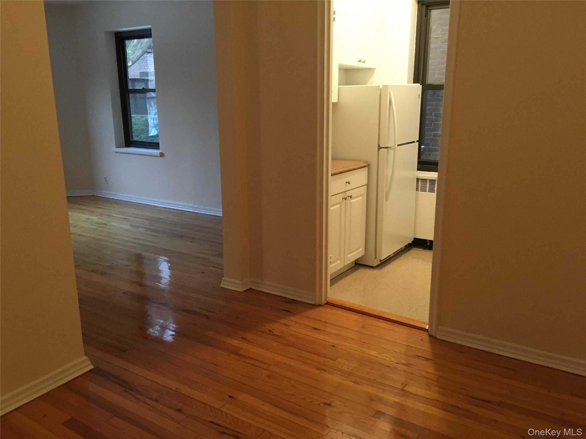 23 Schenck Avenue, Unit 1BD Great Neck, NY 11021 - Photo 10 of 14 an empty room with wooden floor and entrance