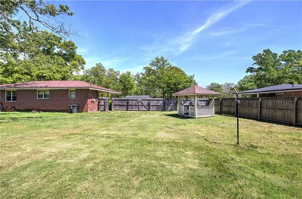 a view of a house with backyard and sitting area