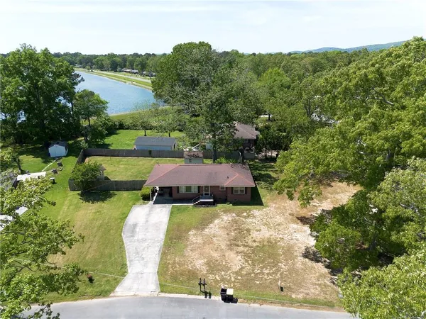 an aerial view of residential house with outdoor space and trees all around