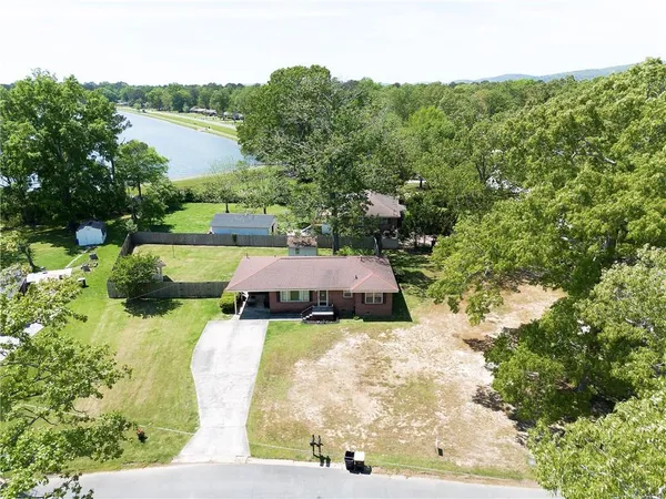an aerial view of lake residential house with outdoor space and trees around