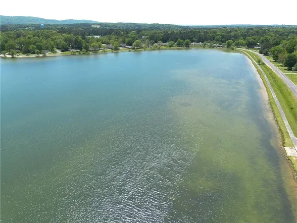 an aerial view of residential houses with outdoor space and trees