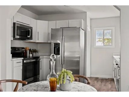 a kitchen with stainless steel appliances kitchen island granite countertop a refrigerator and a stove top oven