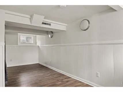 a view of a room with wooden floor and white walls