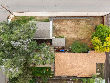 an aerial view of a house with a yard and large tree