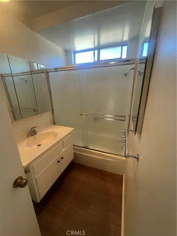 an empty room with windows and chandelier fan