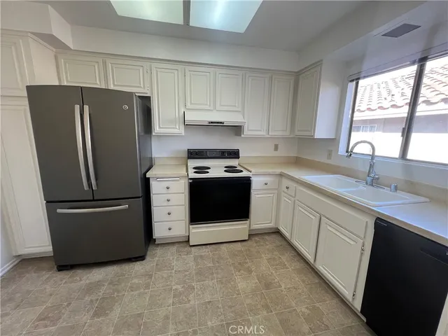 a kitchen with a refrigerator sink and cabinets