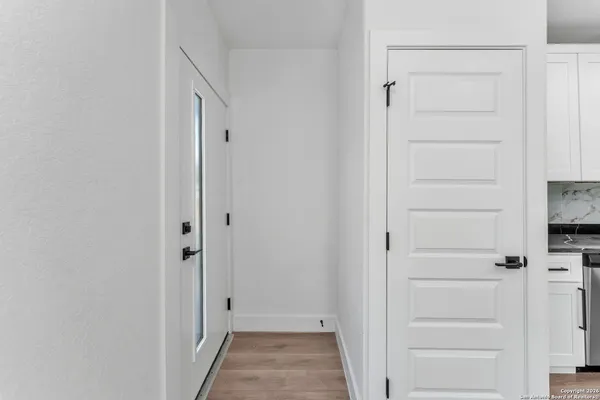 a large kitchen with stainless steel appliances granite countertop a stove a sink and white cabinets