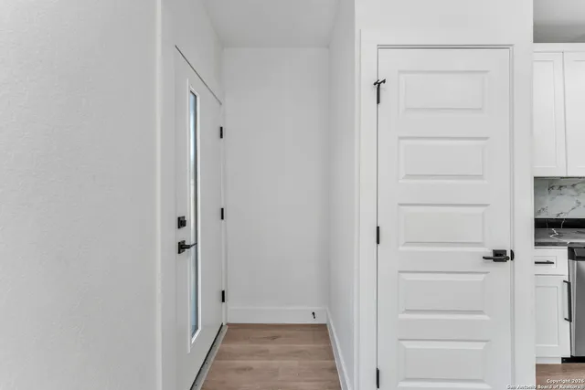 a large kitchen with stainless steel appliances granite countertop a stove a sink and white cabinets
