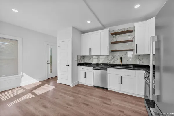 a kitchen with stainless steel appliances granite countertop a stove a sink and a refrigerator