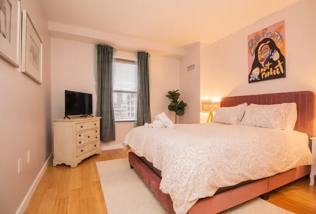 a spacious bedroom with a bed and a flat screen tv