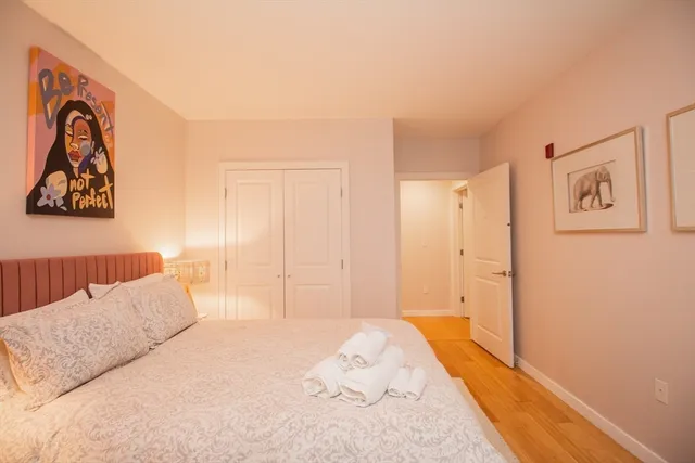 a bedroom with a bed and a painting on the wall