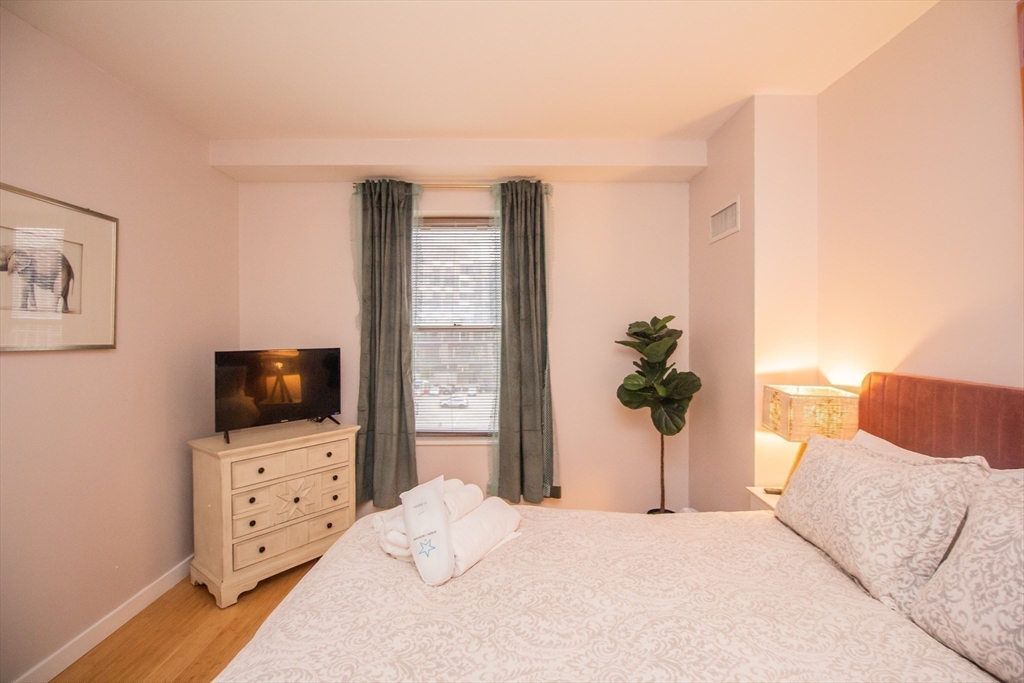 16 Miner Street, Unit 401 Boston, MA 02215 - Photo 21 of 25 a bedroom with furniture and flat screen tv