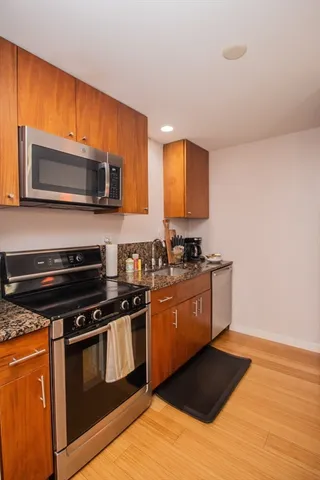 a kitchen with stainless steel appliances granite countertop a stove a sink and a microwave