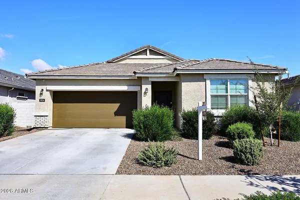 a front view of a house with a garden and plants
