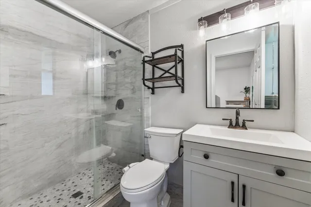 a bathroom with a sink a toilet and shower
